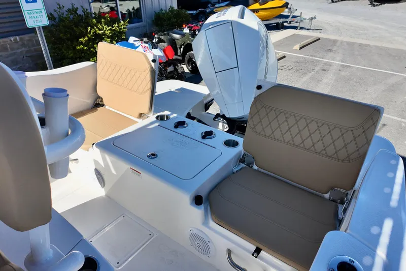 Slide: The Image of 2026 Bayliner Trophy T22CC boat interior with tan seating and white motor. - 8