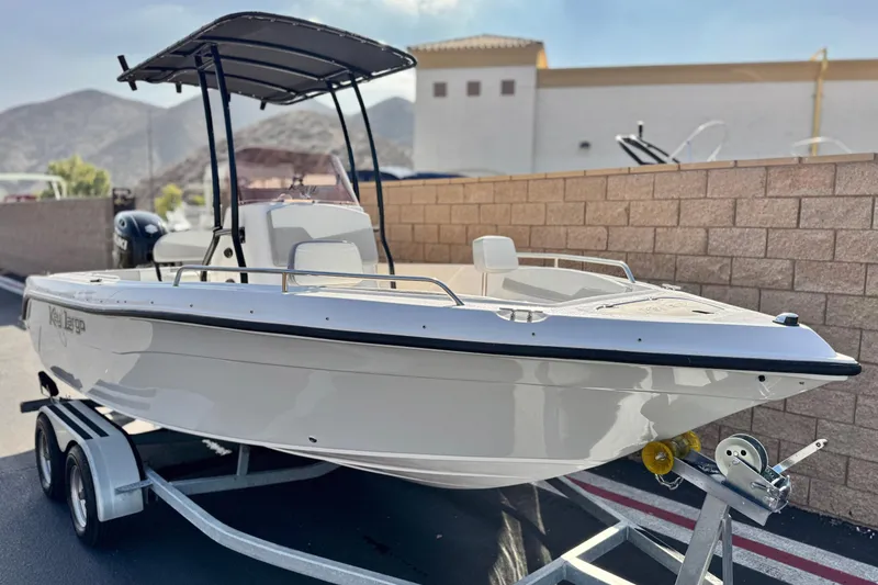 Slide: The Image of 2023 Key Largo 2001 CC boat on trailer, parked outdoors with mountains in background. - 1