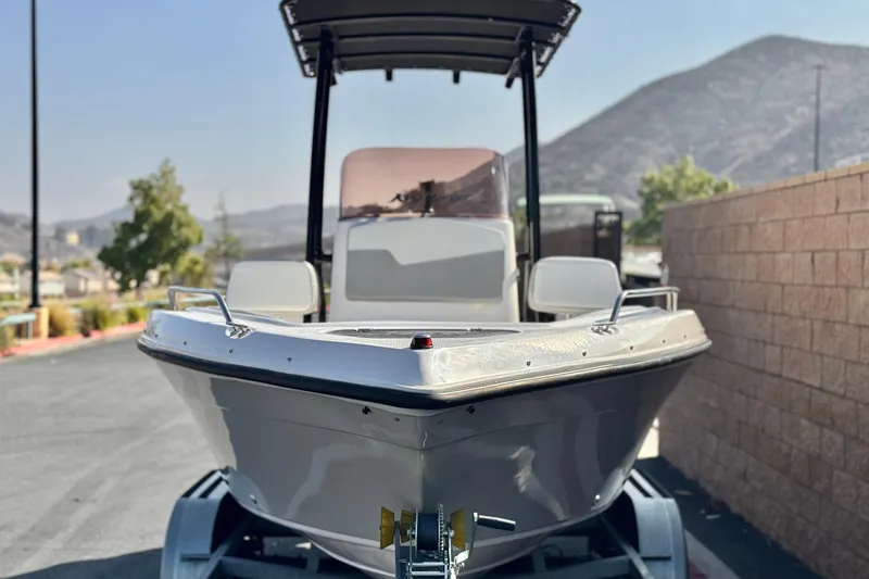 Slide: The Image of Key Largo 2001 CC boat, 2023 model, parked on trailer with mountain backdrop. - 2