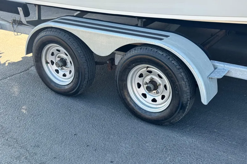 Slide: The Image of Trailer wheels of a 2023 Key Largo 2001 CC boat on pavement. - 27