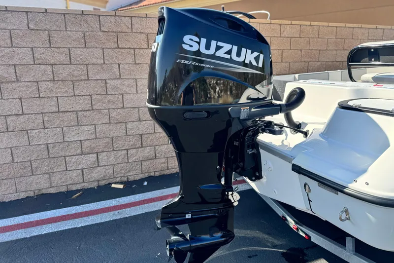 Slide: The Image of Key Largo 2001 CC boat with Suzuki outboard motor, 2023 model, parked near brick wall. - 6