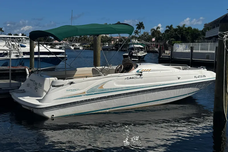 The Image of 1996 Sea Ray 240 Sundeck boat on stands, palm trees in background. - 0
