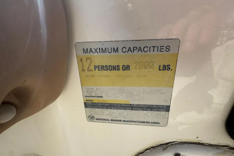 Slide: The Image of 1996 Sea Ray 240 Sundeck boat docked, featuring a green canopy and spacious seating. - 24