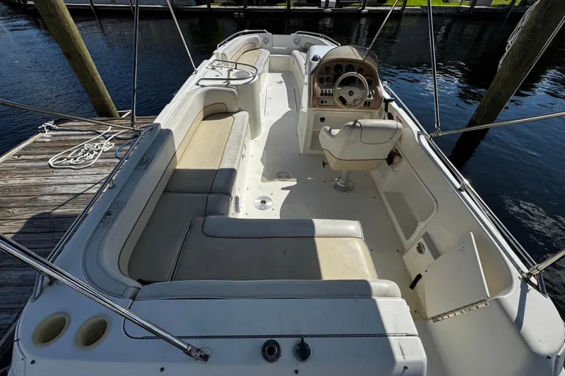 Slide: The Image of 1996 Sea Ray 240 Sundeck boat interior with seating and steering wheel at dock. - 3
