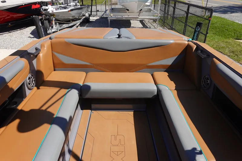 Slide: The Image of 2022 Axis T23 boat interior with brown and gray seating, outdoor setting. - 13