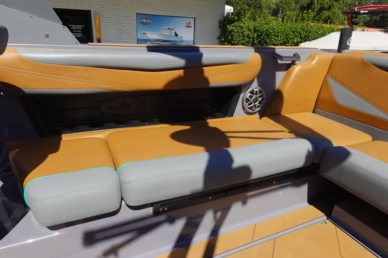 Slide: The Image of 2022 Axis T23 boat interior with tan and gray seating, featuring a speaker and modern design. - 15