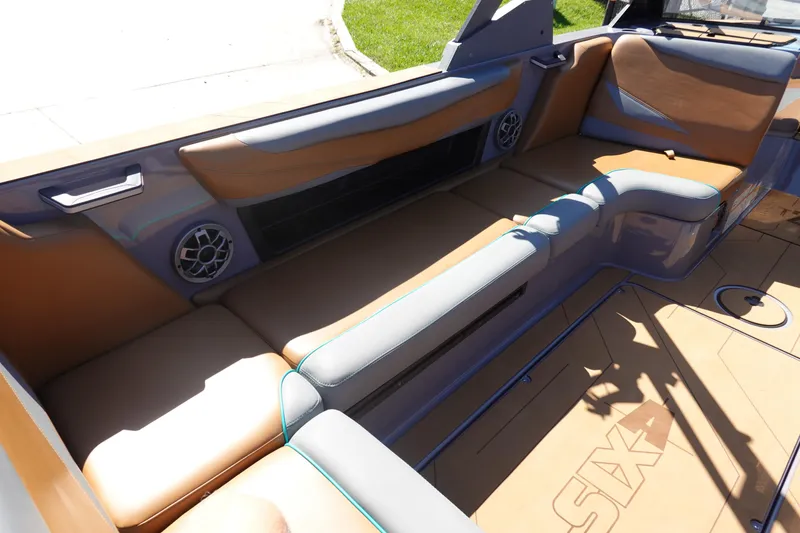 Slide: The Image of 2022 Axis T23 boat interior with tan and gray seating, featuring built-in speakers. - 19