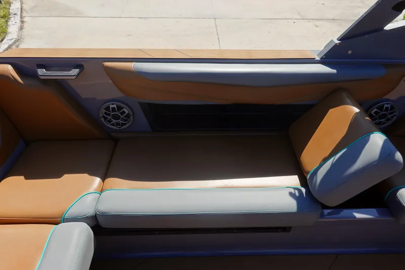 Slide: The Image of 2022 Axis T23 boat interior with tan and gray seating, featuring built-in speakers. - 22