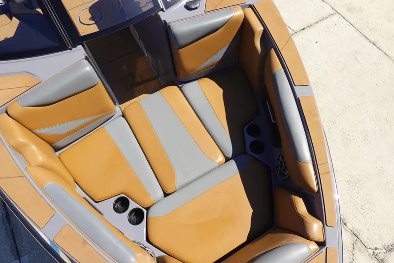 Slide: The Image of 2022 Axis T23 boat interior with tan and gray seating, cup holders, and speaker. - 28