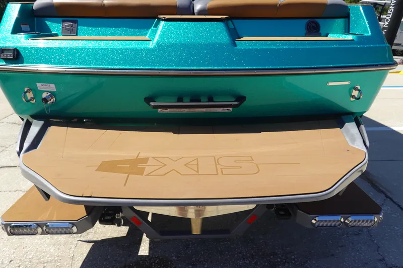 Slide: The Image of 2022 Axis T23 boat rear view with teal finish and swim platform. - 5