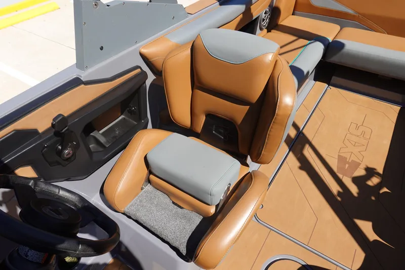 Slide: The Image of 2022 Axis T23 boat interior with tan and gray seating, steering wheel, and dashboard. - 9