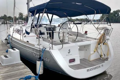 The Image of 2013 Beneteau Oceanis 37 sailboat docked with blue canopy and white hull. - 0