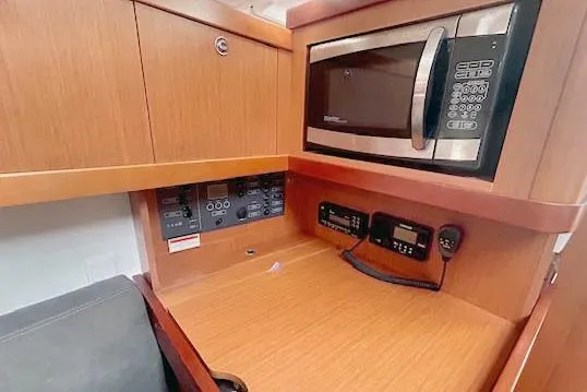 Slide: The Image of 2013 Beneteau Oceanis 37 interior with microwave and control panels in wooden cabinetry. - 8