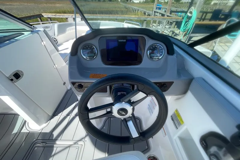 Slide: The Image of 2022 Chaparral 23 SSi boat dashboard with steering wheel and navigation display. - 10