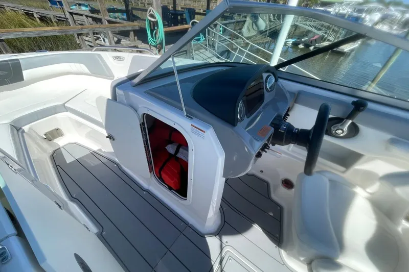 Slide: The Image of 2022 Chaparral 23 SSi boat interior with open storage compartment and steering console. - 13