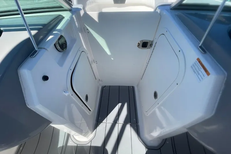 Slide: The Image of 2022 Chaparral 23 SSi boat interior with storage compartments and sleek design. - 14