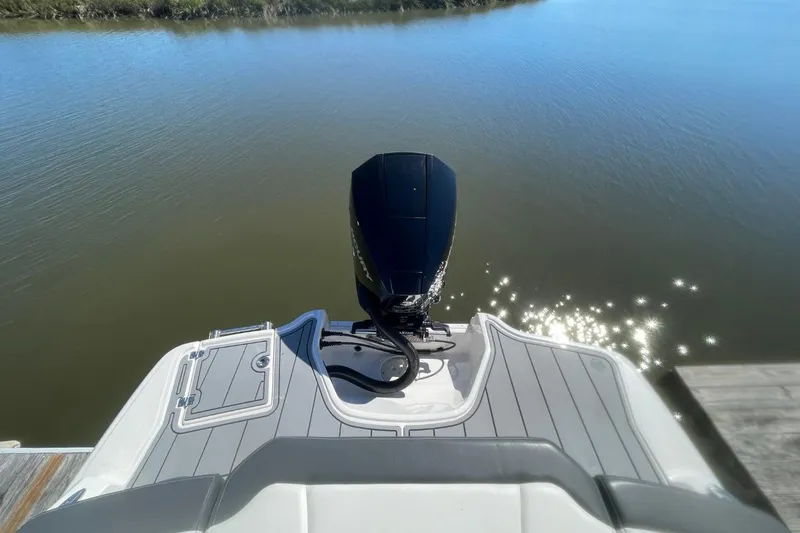 Slide: The Image of 2022 Chaparral 23 SSi boat with outboard motor on calm water. - 18