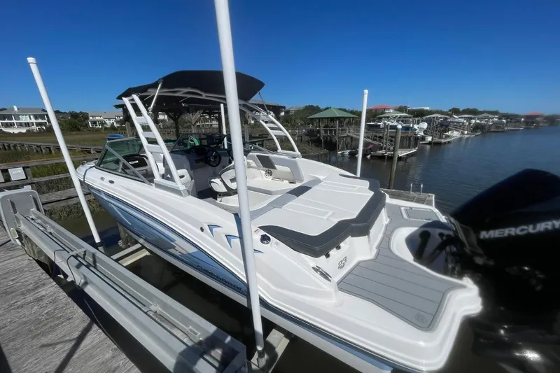 Slide: The Image of 2022 Chaparral 23 SSi boat docked, featuring sleek design and spacious seating. - 4