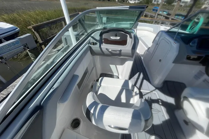 Slide: The Image of 2022 Chaparral 23 SSi boat interior with sleek seating and modern dashboard design. - 9