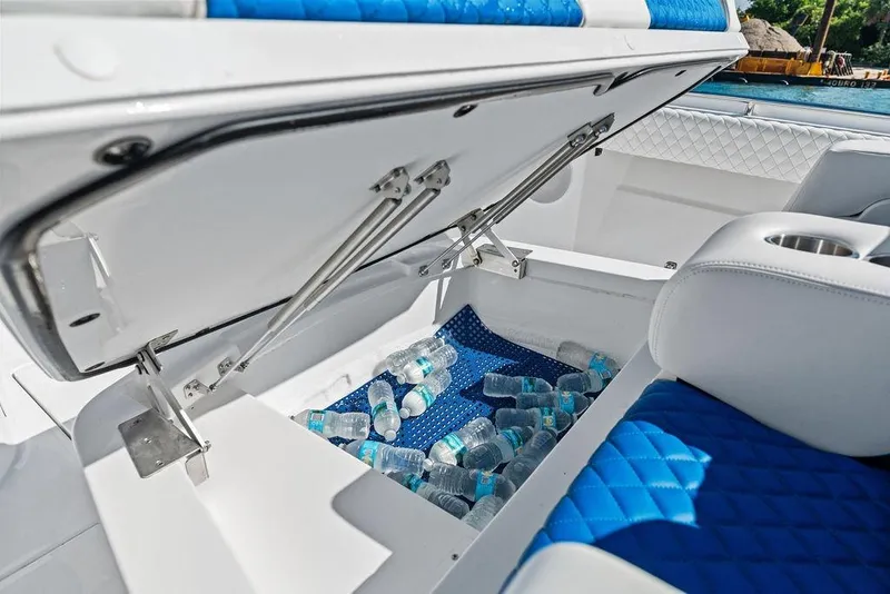Slide: The Image of Open storage compartment on 2025 HCB 53 Suenos RXV boat with water bottles inside. - 33