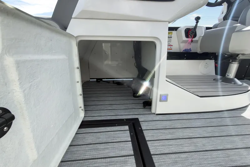 Slide: The Image of 2026 Montara Surf Boss 2.0 SL 23" boat dashboard with storage compartment open. - 35