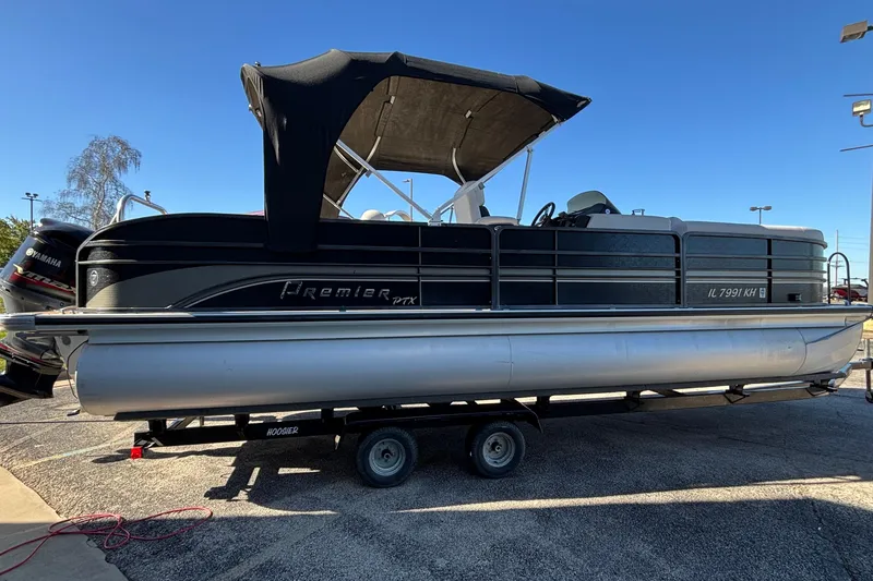 Slide: The Image of 2010 Premier 250 Grand Isle pontoon boat on trailer, with Yamaha engine, under clear blue sky. - 5