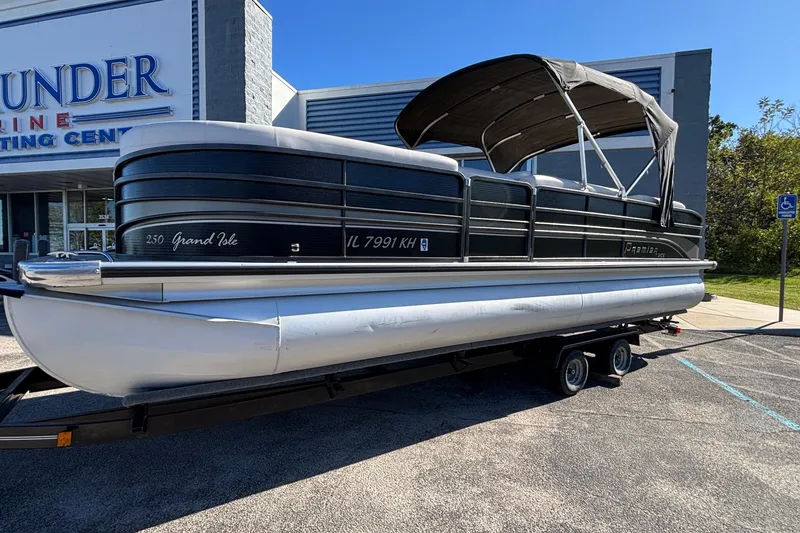 Slide: The Image of 2010 Premier 250 Grand Isle pontoon boat on trailer outside marine center. - 7