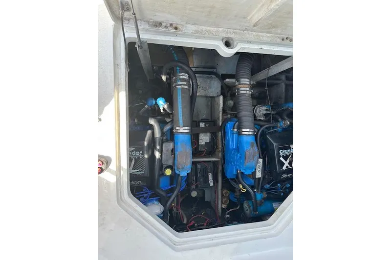 Slide: The Image of Engine compartment of a 1993 Silverton Express boat, featuring blue components and hoses. - 10