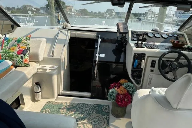 Slide: The Image of 1993 Silverton Express boat interior with floral decor and steering wheel, docked at marina. - 3