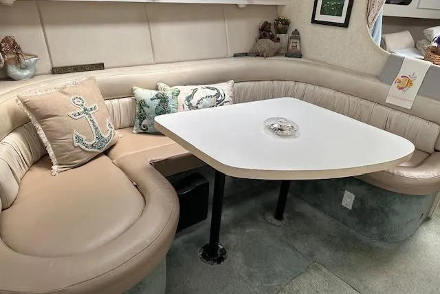 Slide: The Image of 1993 Silverton Express yacht interior with cozy seating and nautical-themed pillows. - 4