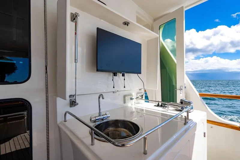 Slide: The Image of Outdoor kitchen on 2015 Marlow 66E-CB yacht with sink, TV, and ocean view. - 10