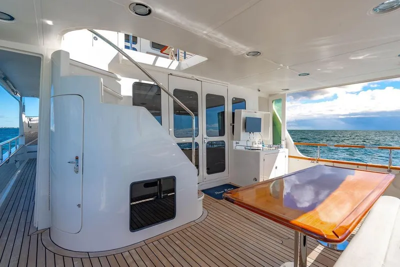 Slide: The Image of Luxurious 2015 Marlow 66E-CB yacht deck with elegant wood table and ocean view. - 2