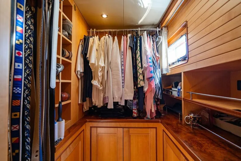 Slide: The Image of Luxurious wooden closet with hanging clothes and shelves in a 2015 Marlow 66E-CB yacht. - 28