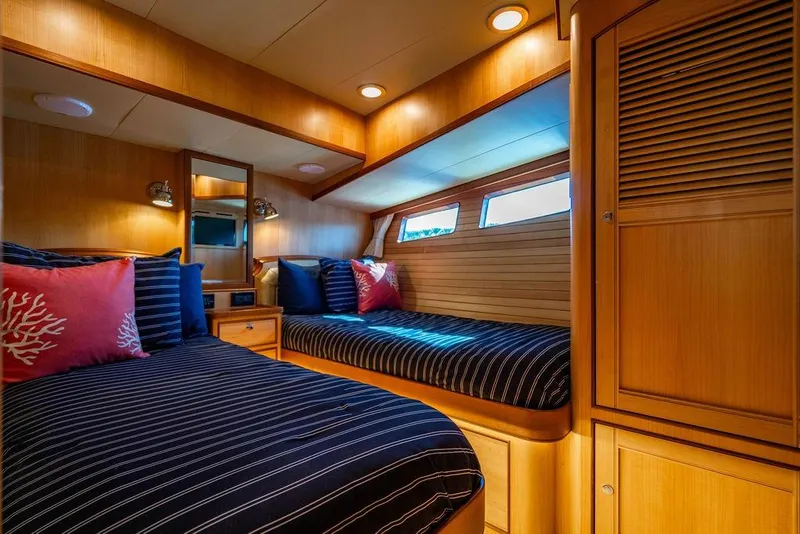 Slide: The Image of Luxurious cabin interior of 2015 Marlow 66E-CB yacht with striped bedding and wooden finishes. - 34