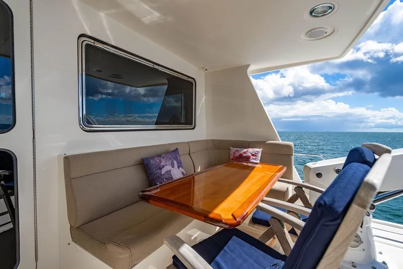 Slide: The Image of Outdoor seating area on 2015 Marlow 66E-CB yacht with ocean view and cushions. - 43