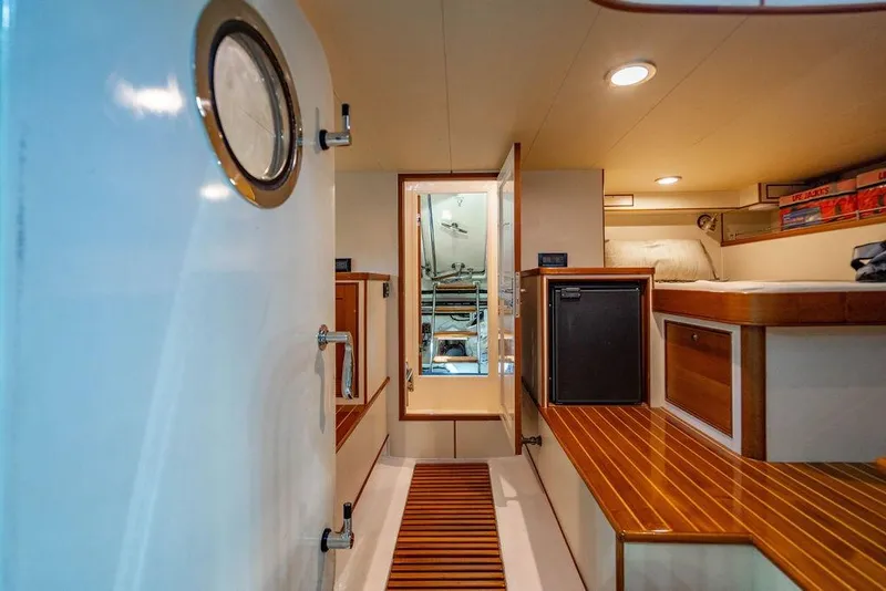 Slide: The Image of Interior of 2015 Marlow 66E-CB yacht with wooden flooring and compact cabin space. - 52