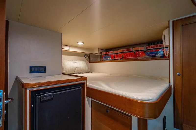 Slide: The Image of Cozy cabin interior of 2015 Marlow 66E-CB yacht with bed and life jackets. - 53