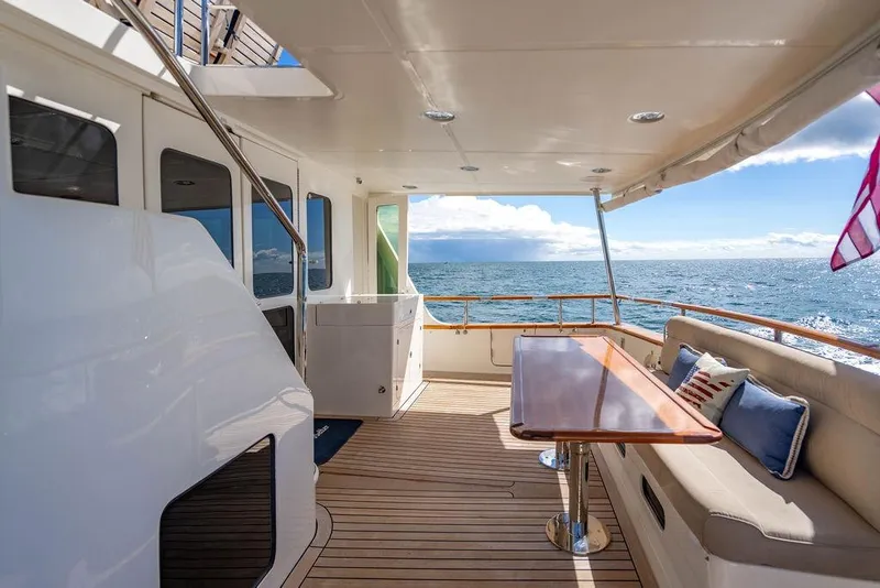 Slide: The Image of Luxurious 2015 Marlow 66E-CB yacht deck with seating, table, and ocean view. - 9