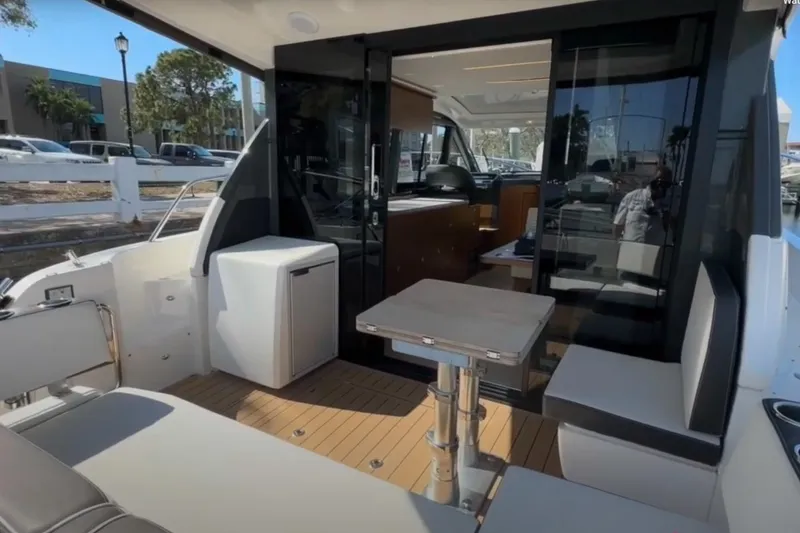 Slide: The Image of 2023 Bavaria R40 Coupe yacht interior with seating, table, and glass doors. - 10