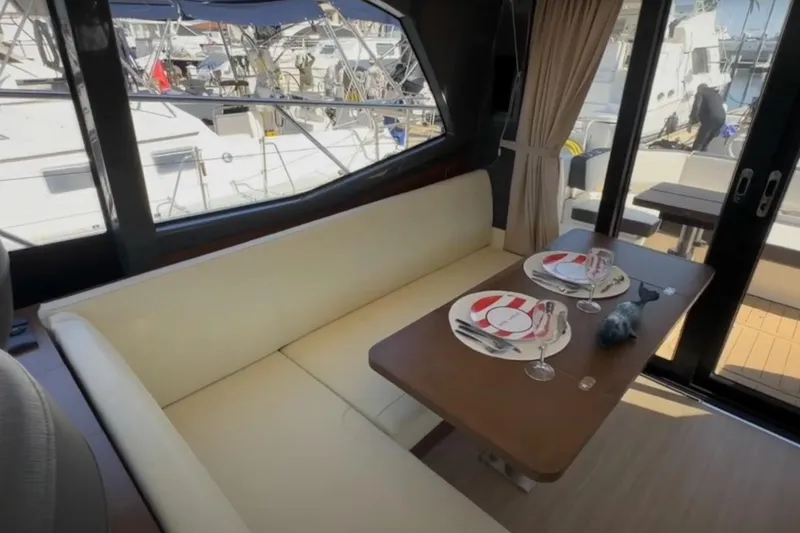 Slide: The Image of Interior of 2023 Bavaria R40 Coupe yacht with elegant dining setup and marina view. - 20