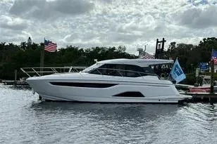 Slide: The Image of 2023 Bavaria R40 Coupe yacht docked on a cloudy day with flags. - 6
