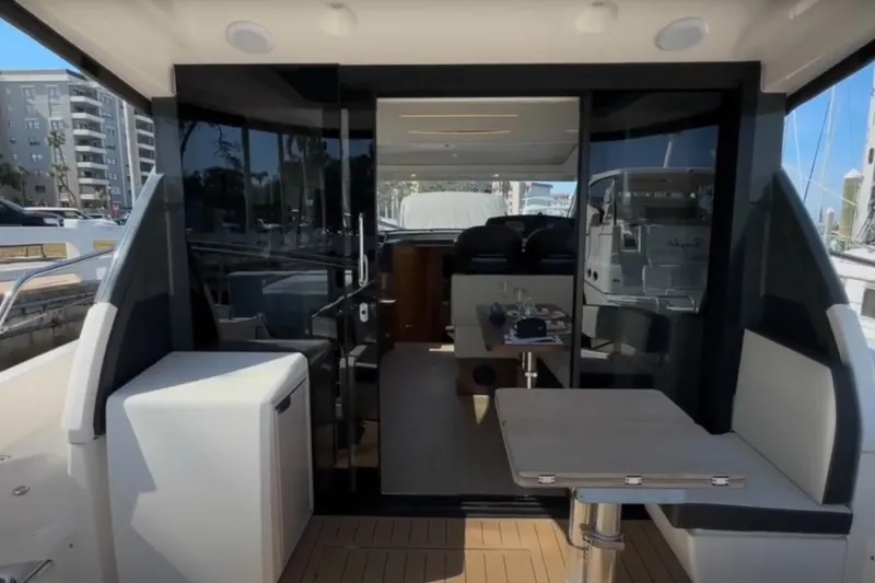 Slide: The Image of 2023 Bavaria R40 Coupe yacht interior with modern seating and table setup. - 9