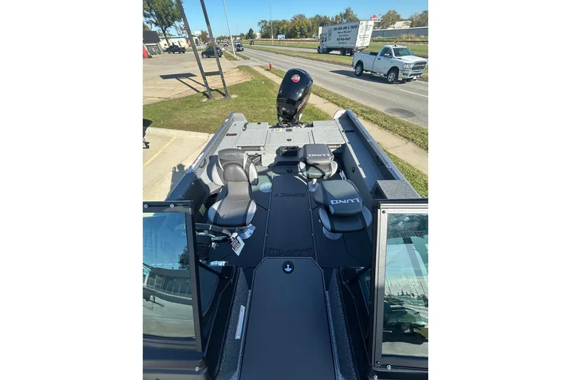 Slide: The Image of 2026 Lund 1875 Impact XS Sport boat on trailer under clear blue sky. - 13