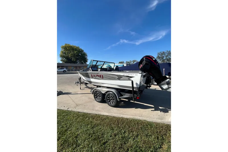 Slide: The Image of 2026 Lund 1875 Impact XS Sport boat on display, viewed from above, near a road. - 17