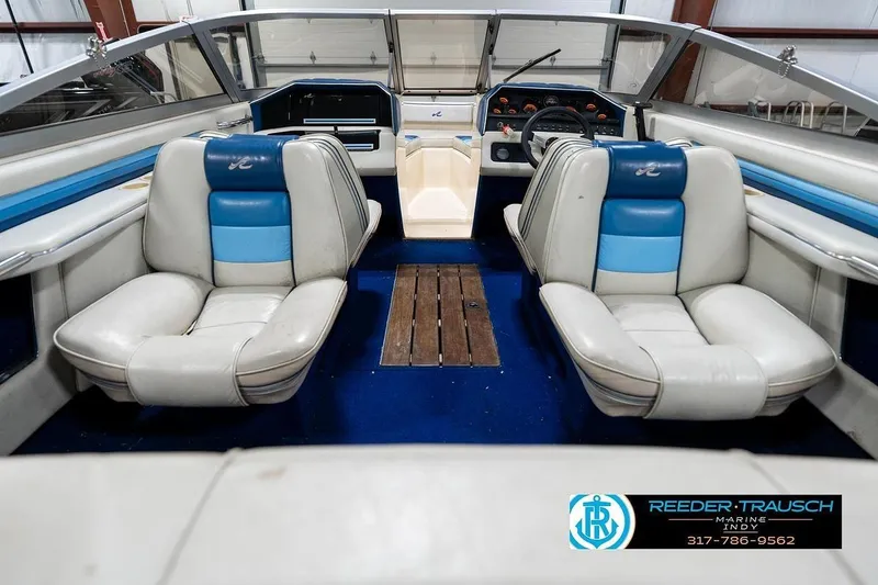 Slide: The Image of 1987 Sea Ray Sorrento 21 boat interior with blue and white seating, wooden flooring, and dashboard. - 15