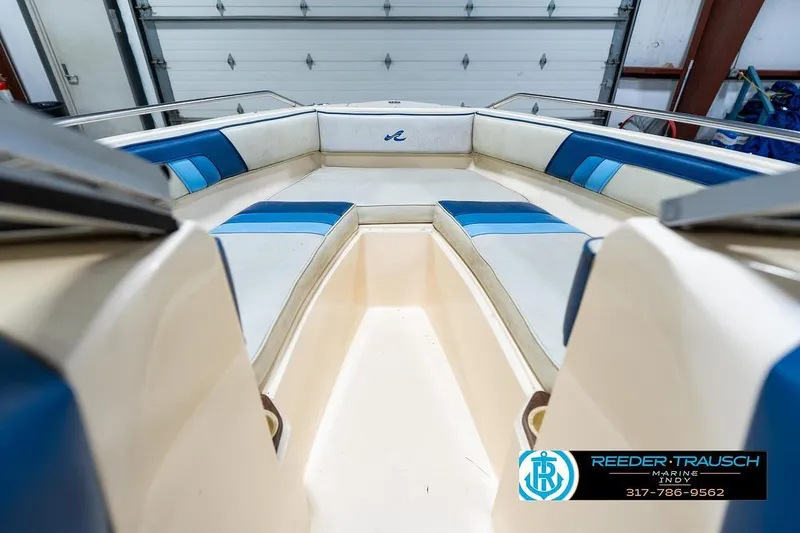 Slide: The Image of 1987 Sea Ray Sorrento 21 boat interior with blue and white seating in a garage. - 17