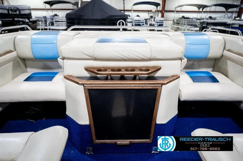 Slide: The Image of 1987 Sea Ray Sorrento 21 boat interior with blue and white seating, cup holders, and wood accents. - 26