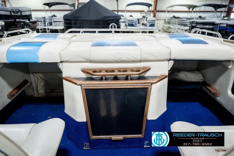 Slide: The Image of 1987 Sea Ray Sorrento 21 boat interior with blue and white seating, cup holders, and wood accents. - 27