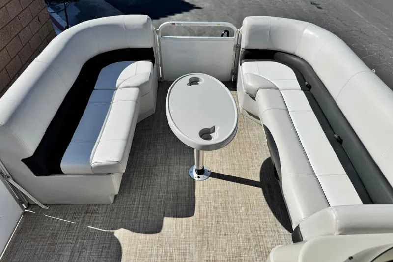 Slide: The Image of 2020 SunCatcher V24 SS pontoon boat interior with white seating and oval table. - 10