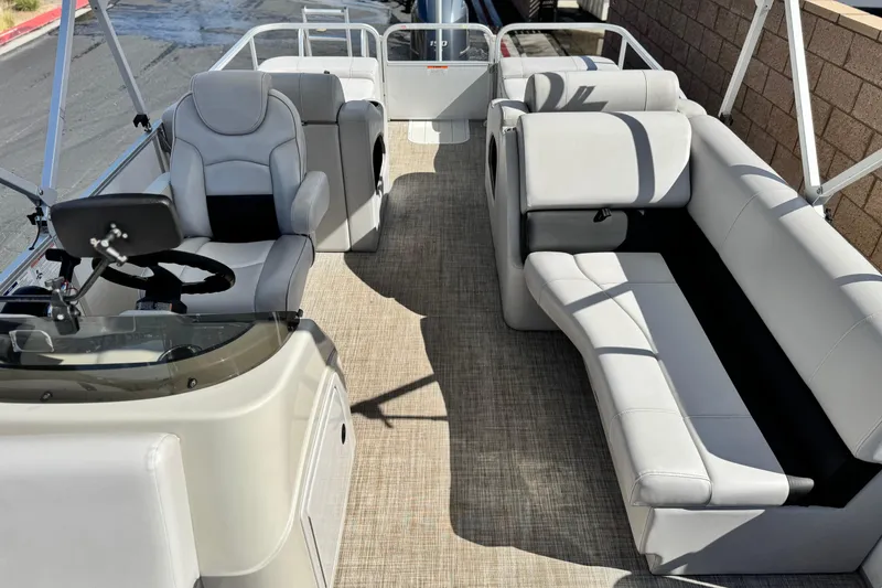 Slide: The Image of 2020 SunCatcher V24 SS pontoon boat interior with plush seating and steering console. - 13